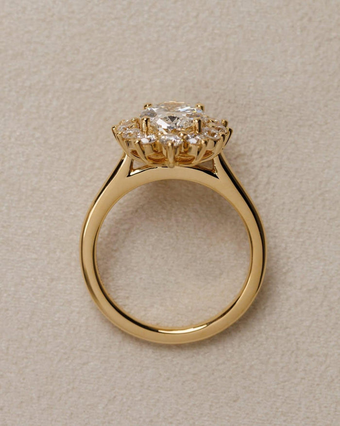 Oval cut lab grown diamond halo engagement ring with floral sunburst cluster in solid gold