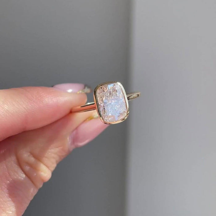 Handmade cushion moissanite bezel promise ring, angled view