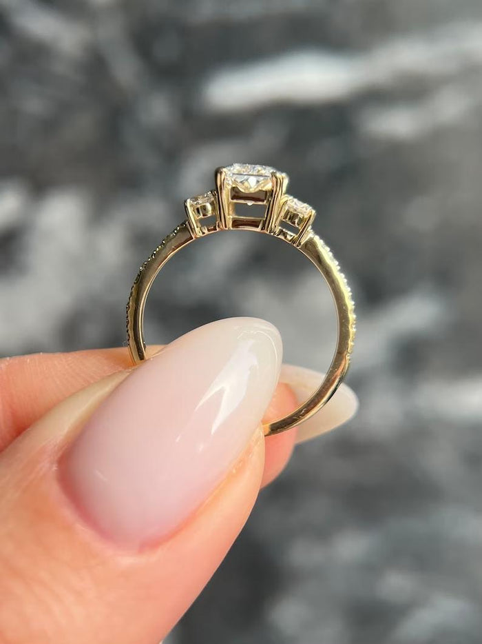 Radiant cut lab grown diamond three stone engagement ring with trillion side stones in yellow gold