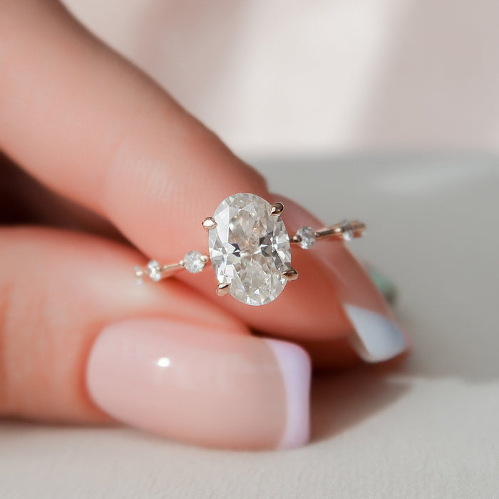 Oval cut moissanite solitaire engagement ring in rose gold held in hand