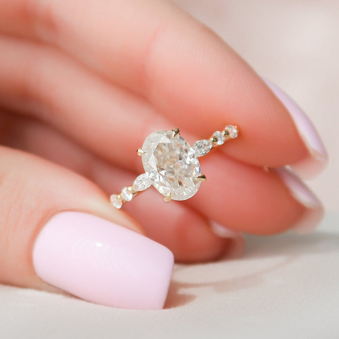 Oval cut moissanite hidden halo engagement ring held in hand