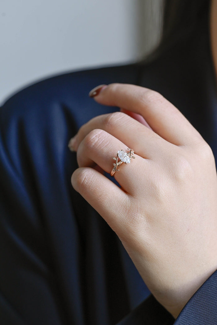 Marquise cut moissanite engagement ring on a rose gold band of twisting vines with small textured leaves, view 2