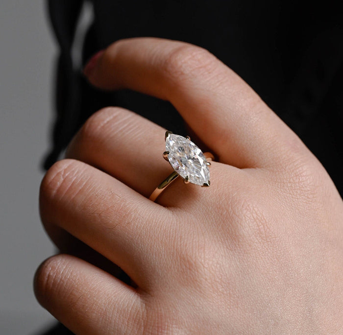 Large marquise cut moissanite six claw solitaire engagement ring on a plain polished yellow gold band, view 2