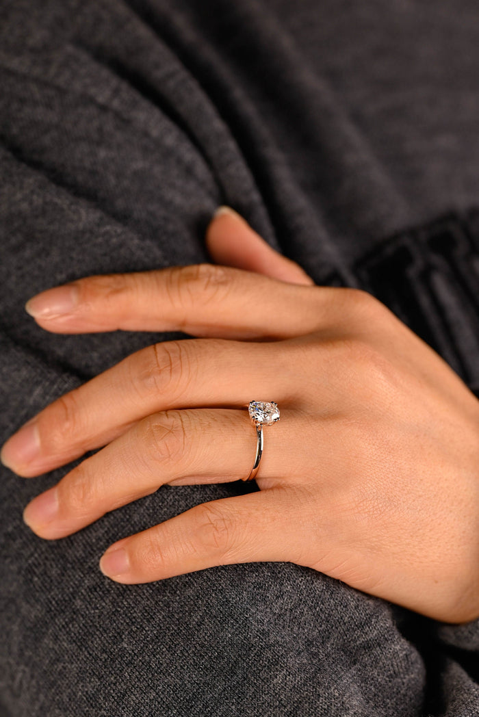 Oval moissanite solitaire engagement ring with four double bead claws on a slim plain polished rose gold band, view 2