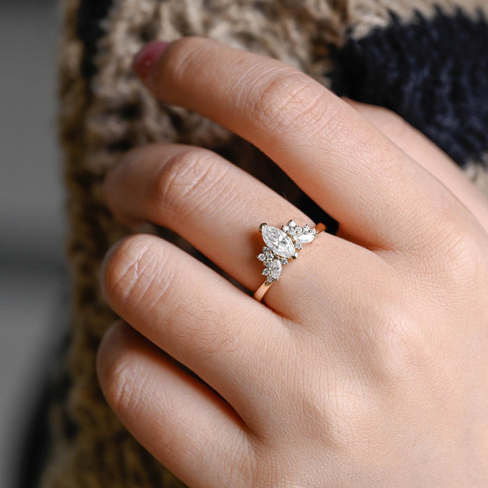 Marquise cut moissanite wing cluster engagement ring with round and marquise accent stones on a slim yellow gold band, view 2
