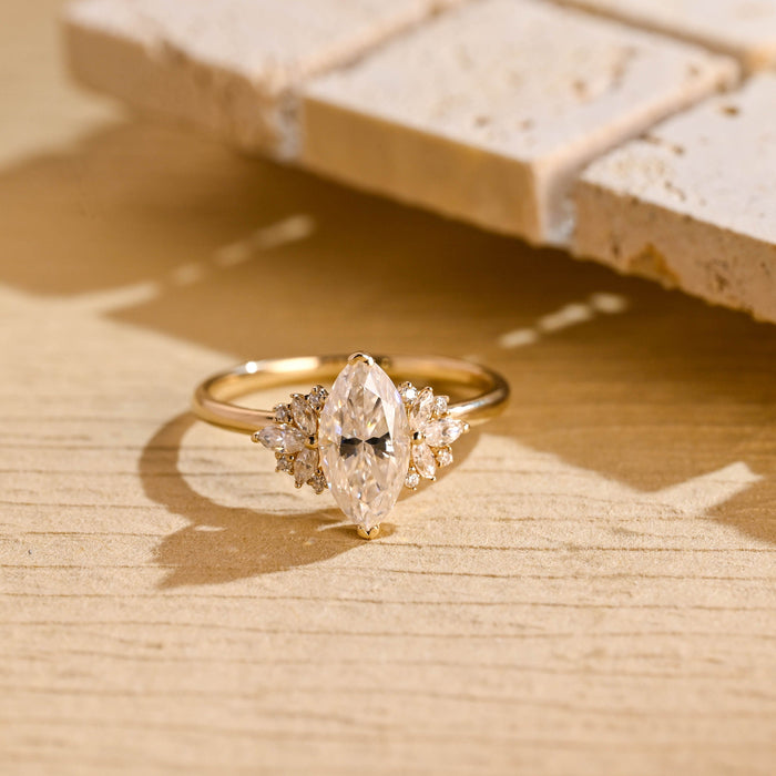 Marquise cut moissanite petal cluster engagement ring with marquise leaf side stones on a slim yellow gold band