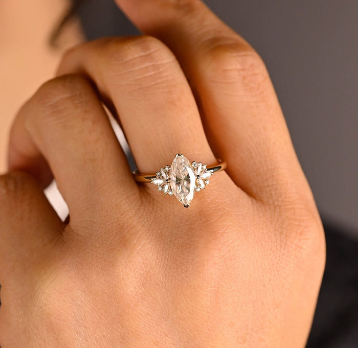 Marquise cut moissanite petal cluster engagement ring with marquise leaf side stones on a slim yellow gold band, view 2