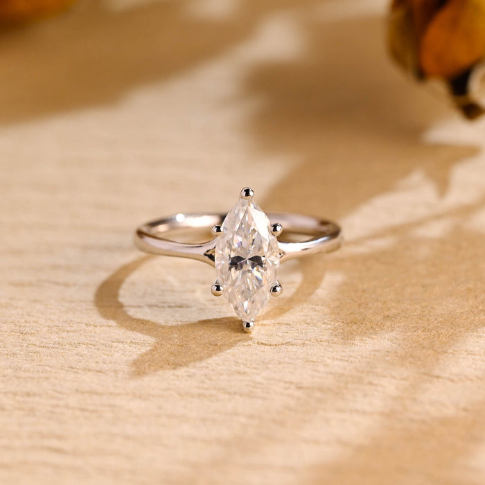 Marquise cut moissanite six claw solitaire engagement ring on a smooth polished white gold band that flares up to the stone