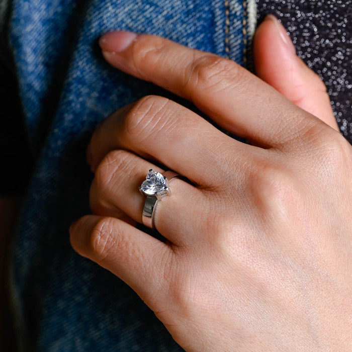 Heart cut moissanite solitaire engagement ring on a wide flat polished white gold band, view 2