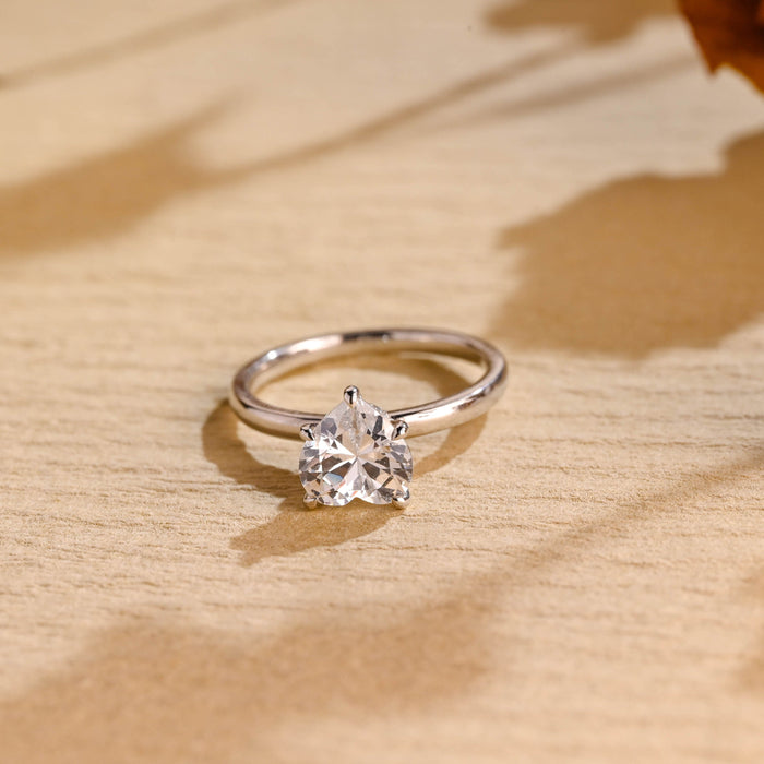 Heart cut moissanite solitaire engagement ring with hidden halo on a plain polished white gold band