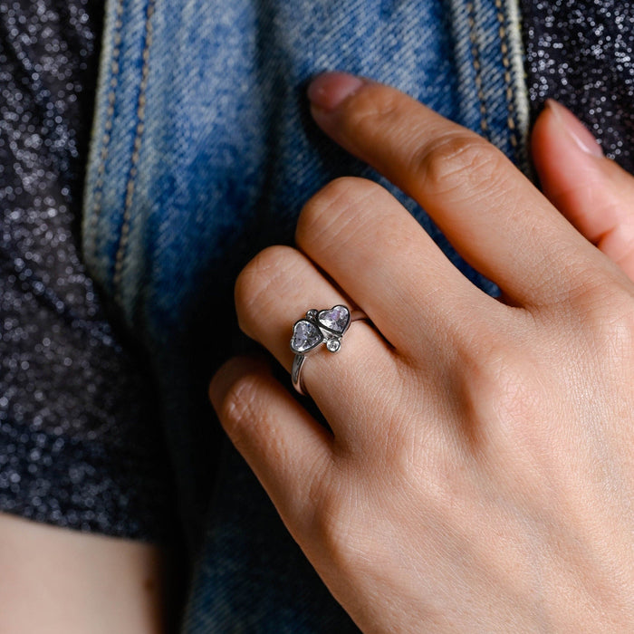 Toi et moi two stone heart cut moissanite bezel engagement ring with two round accent stones on a white gold band, view 2
