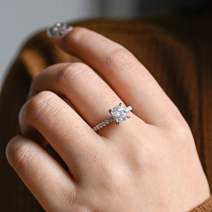 Elongated cushion moissanite hidden halo engagement ring in four claws on a slim white gold band pave set with small round stones, view 2