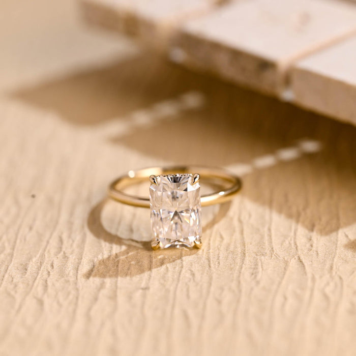 Large radiant cut moissanite hidden halo engagement ring with four claws on a slim polished yellow gold band
