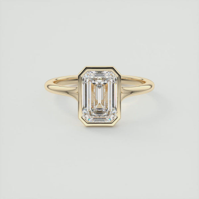 Emerald cut moissanite split shank bezel engagement ring in yellow gold