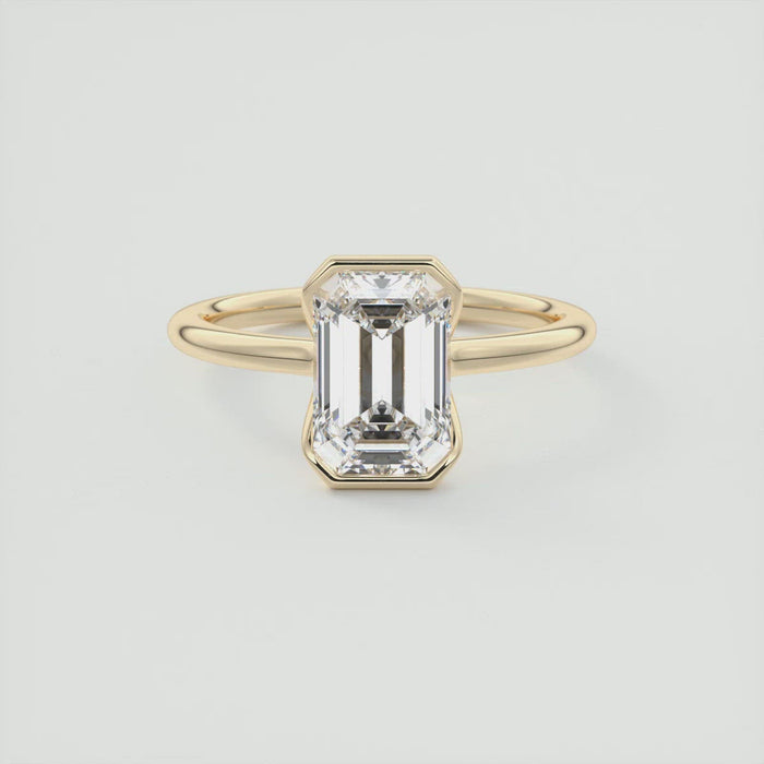 Emerald cut moissanite flush half bezel engagement ring in yellow gold
