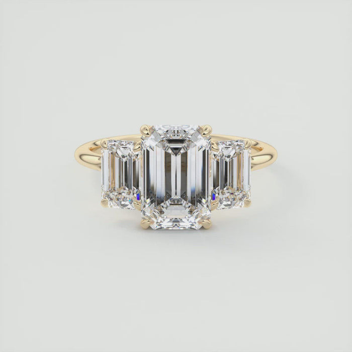 Emerald cut moissanite three stone engagement ring in yellow gold