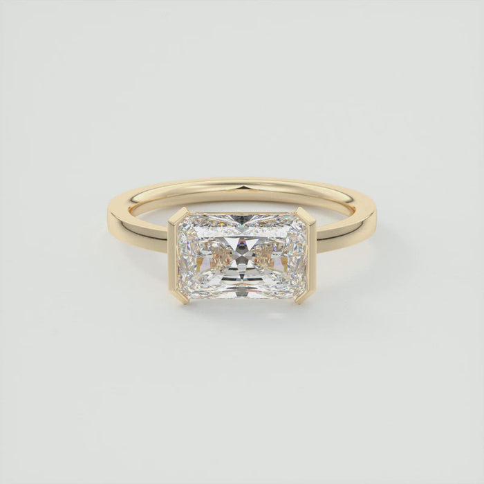 Radiant cut moissanite east west half bezel solitaire ring in yellow gold