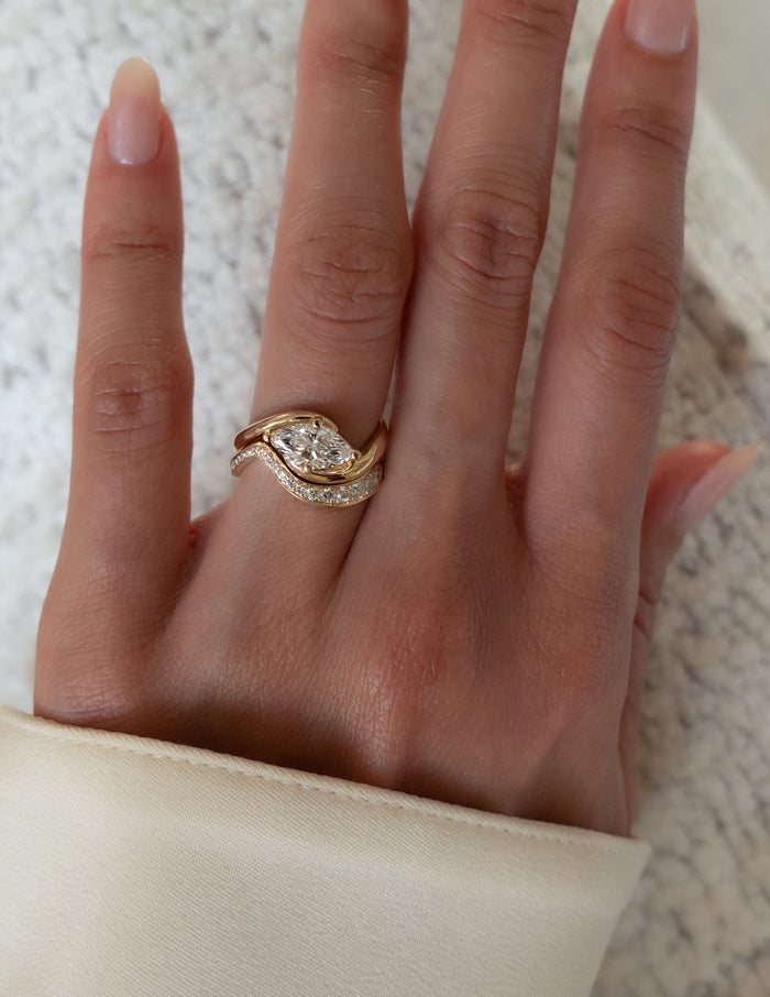 Marquise lab grown diamond swirl bypass ring with curved graduated pave band on the full hand