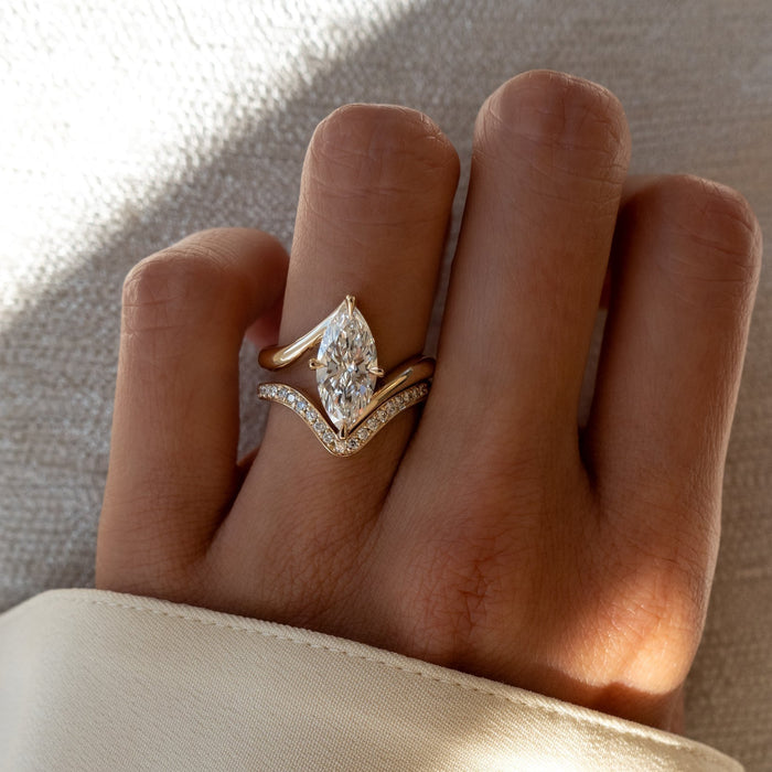 Marquise lab grown diamond swirl bypass bridal set with pave V band in yellow gold on the hand