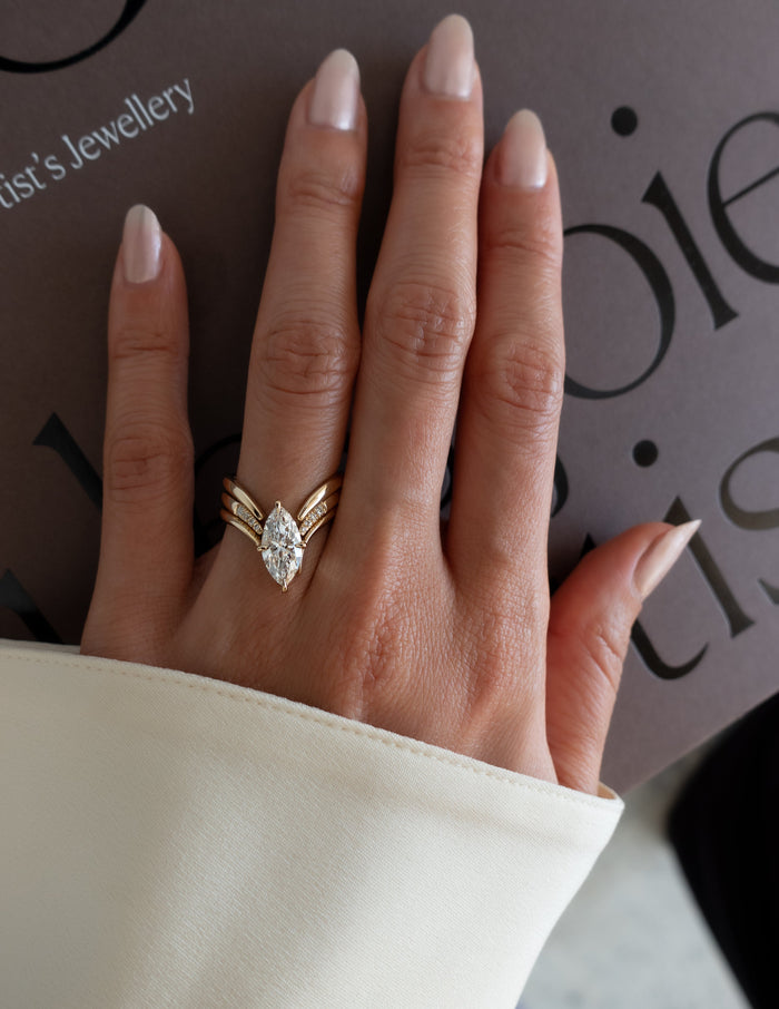 Three-piece marquise lab grown diamond chevron bridal set in yellow gold worn on the hand