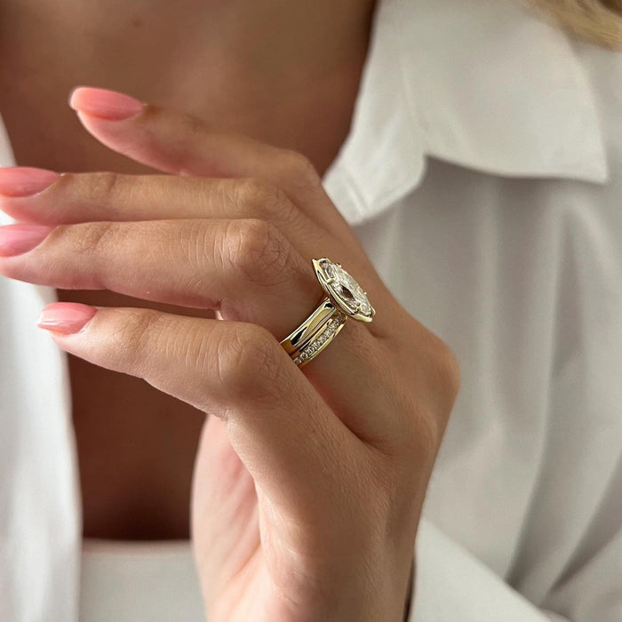 Side view of marquise moissanite ring showing the domed shank and row of stones on the wedding band