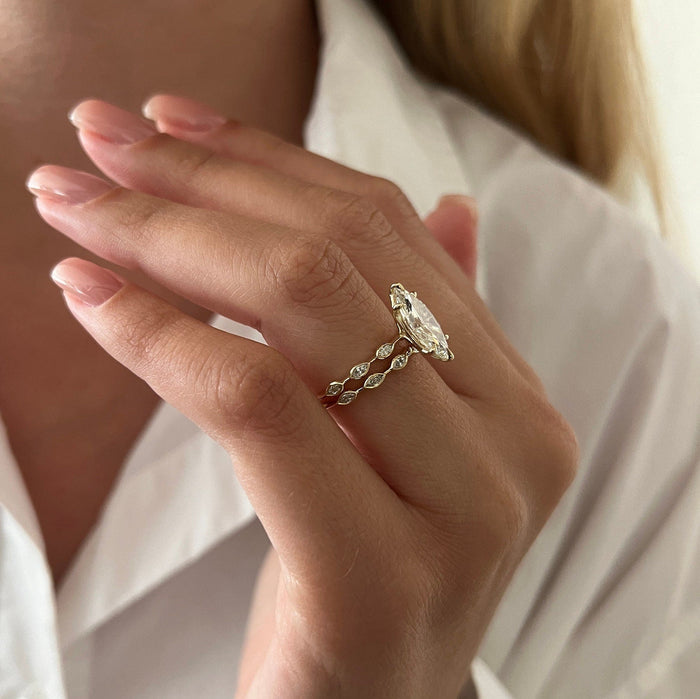 Side view of marquise moissanite ring with bezel-set marquise stations on both bands