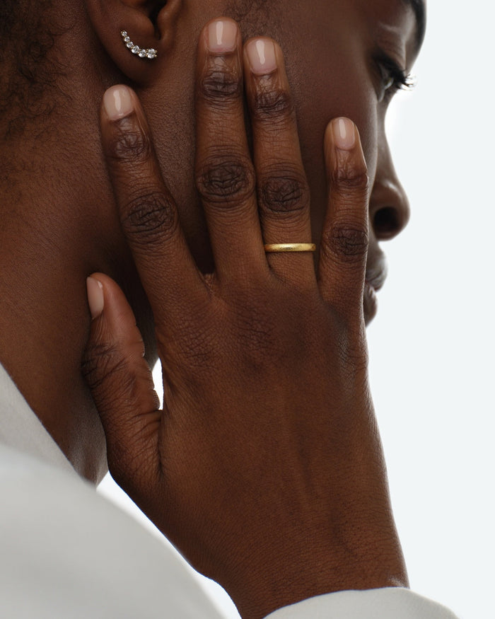 Woman wearing a 2mm stardust finish gold wedding band