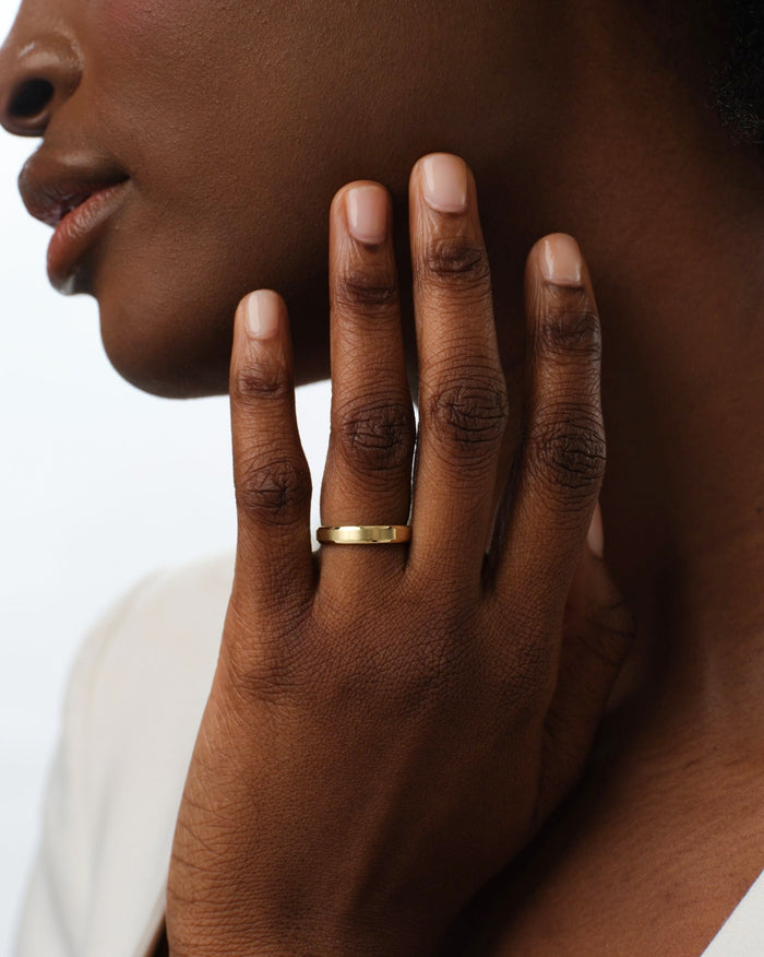 Hand wearing a 4mm matte brushed gold wedding band