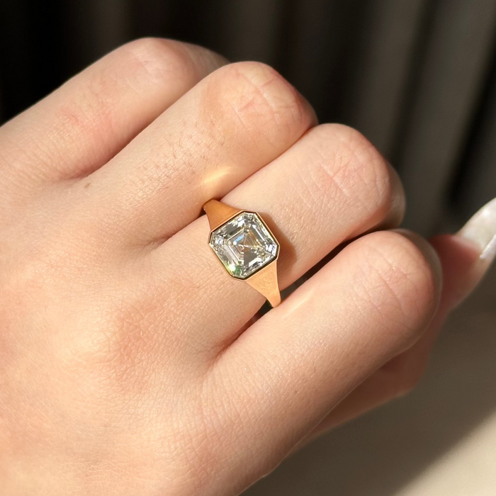 Asscher cut moissanite bezel set engagement ring on a wide tapered yellow gold band, view 2