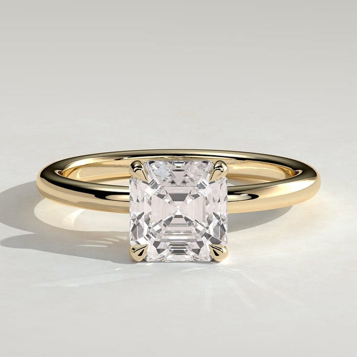 Asscher cut moissanite four claw solitaire engagement ring on a plain yellow gold band