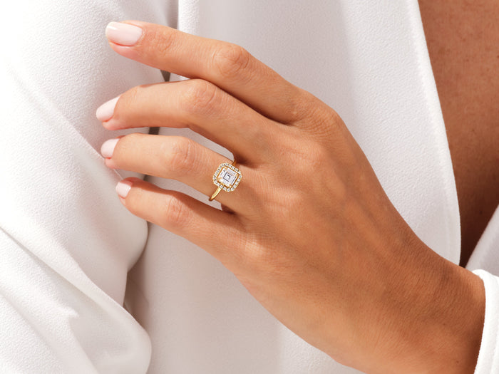 Square Asscher lab grown diamond halo ring in yellow gold on a hand resting at the collar of a white shirt