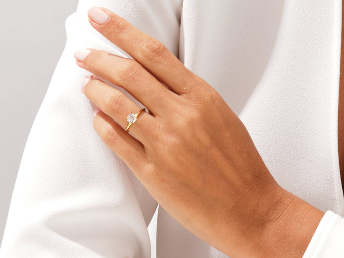 Step cut asscher lab grown diamond solitaire in yellow gold on the ring finger, hand at the shoulder