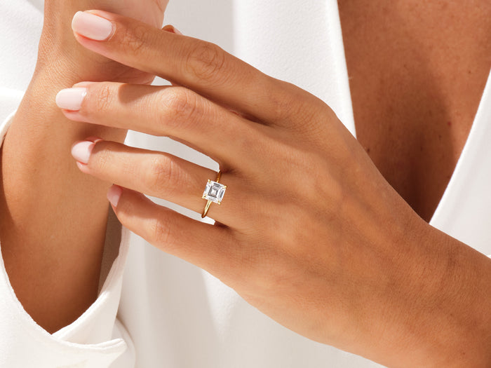 Square Asscher moissanite ring in yellow gold worn on the hand, close view