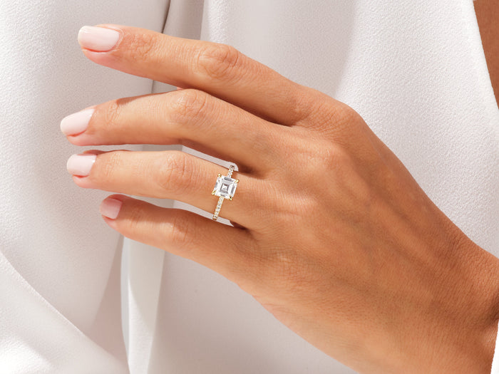 Square Asscher lab grown diamond ring in white gold worn on the hand against white silk