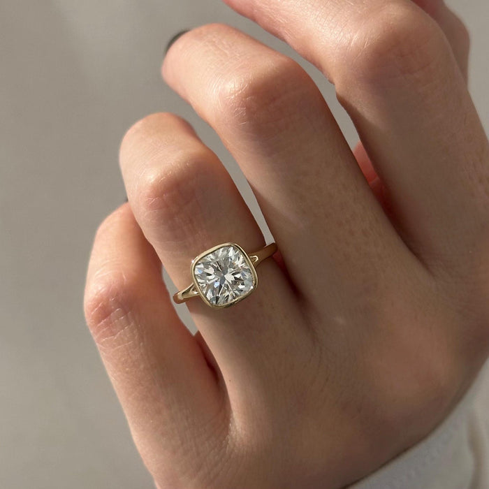 Cushion cut moissanite bezel set solitaire engagement ring in yellow gold, view 2