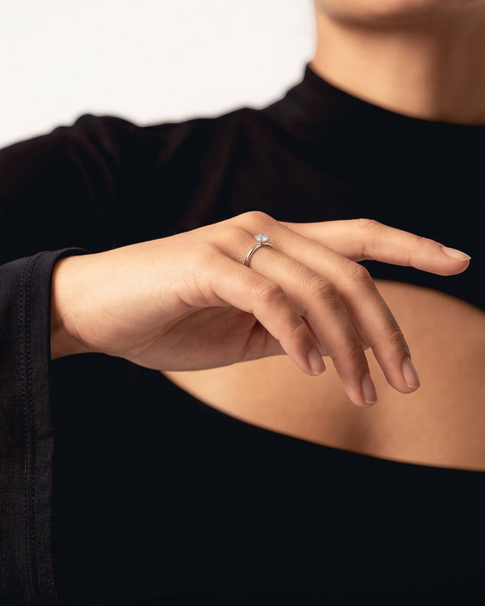 Cushion cut lab grown diamond solitaire ring in white gold worn on an outstretched hand