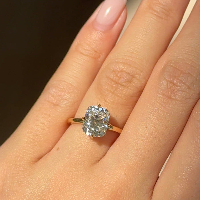 Elongated cushion moissanite hidden halo engagement ring with compass claws in yellow gold