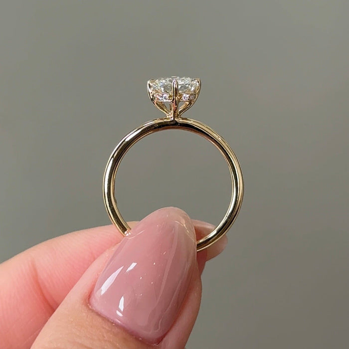 Elongated cushion moissanite hidden halo engagement ring on a very fine yellow gold band, view 2
