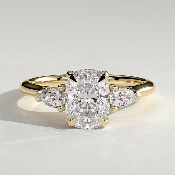Elongated cushion moissanite three stone engagement ring with pear side stones in yellow gold