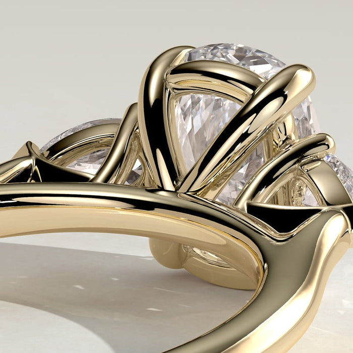 Elongated cushion moissanite three stone engagement ring with pear side stones in yellow gold, view 2