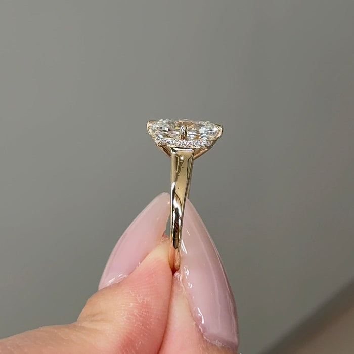 Elongated cushion moissanite hidden halo engagement ring on a tapered yellow gold band, view 2
