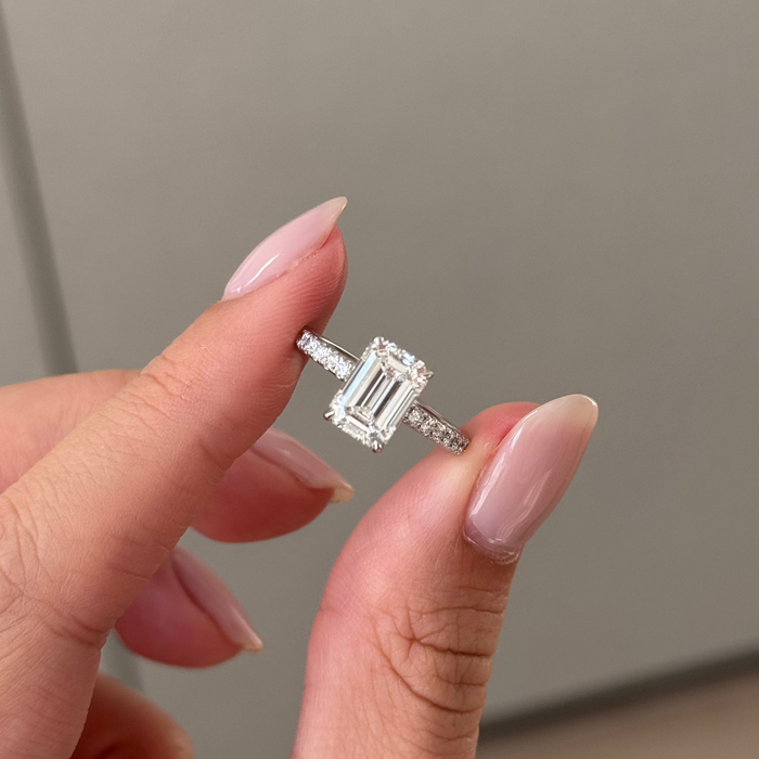 Emerald cut moissanite halo engagement ring on a pave set white gold band