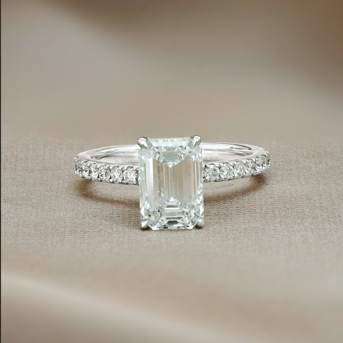 Emerald cut moissanite halo engagement ring on a pave set white gold band, view 2