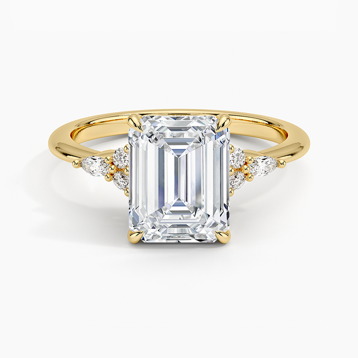 Emerald cut moissanite engagement ring with marquise and round cluster accents in yellow gold, top view