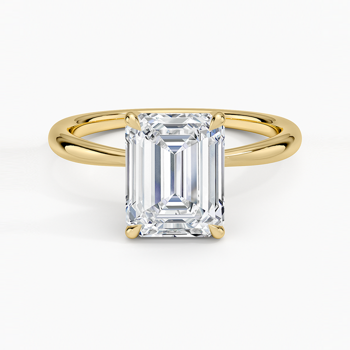 Emerald cut moissanite petite solitaire ring with ultra thin band in yellow gold, top view