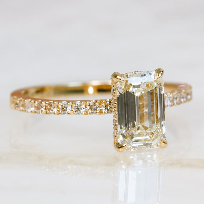 Emerald cut moissanite solitaire engagement ring on a fine pave white gold band, view 2
