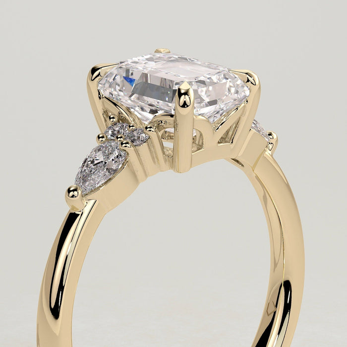 Emerald cut moissanite engagement ring with pear and round cluster shoulders in yellow gold, view 2