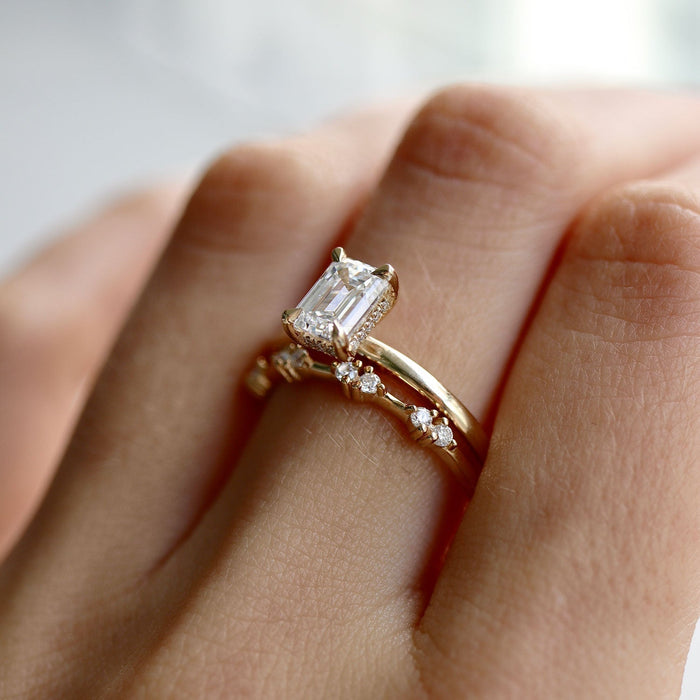 Emerald cut moissanite solitaire engagement ring with a rounded band in yellow gold, view 2