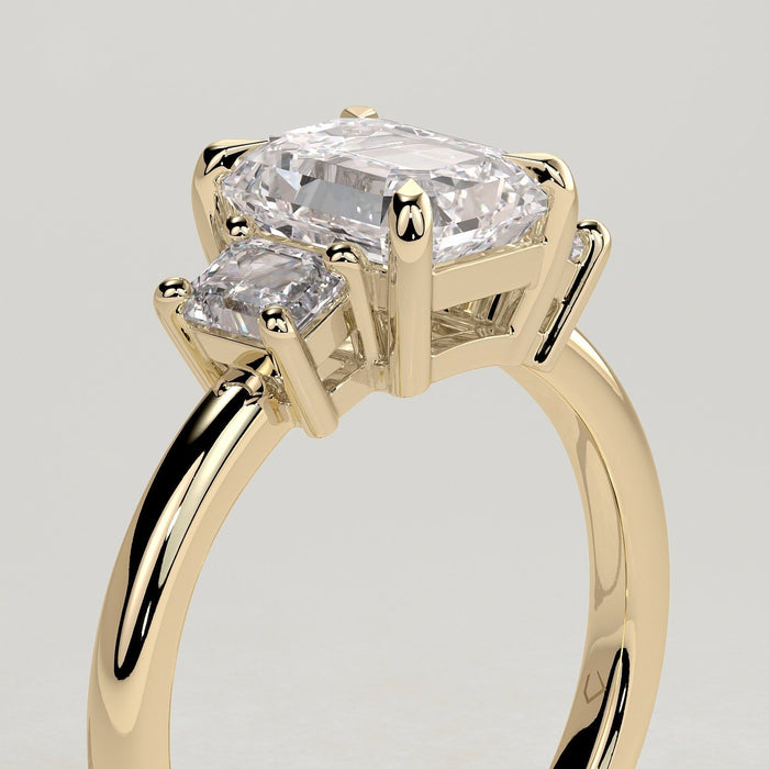 Emerald cut moissanite three stone engagement ring with step cut side stones in yellow gold, view 2