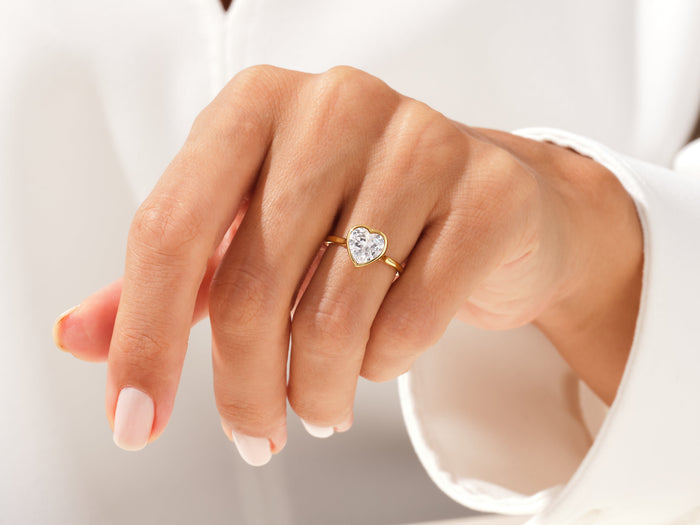Heart shaped moissanite full bezel ring in yellow gold worn on the hand